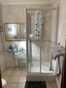 um chuveiro na casa de banho com uma cabina de duche envidraçada. em Tamarisk Guest Lodge em Benoni
