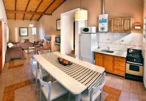eine Küche mit einem Tisch und Stühlen sowie eine Küche mit einer Küche in der Unterkunft Complejo el Paine in Villa General Belgrano
