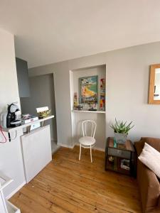 a living room with a couch and a chair at Le Petit Logis - Vue Mer in Granville