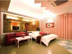 シーライフリゾートホテル في Ashiya: غرفة نوم بسرير واريكة وطاولة