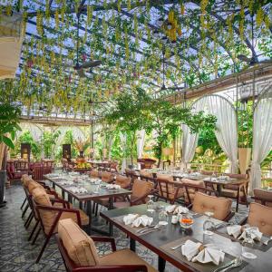 プノンペンにあるPalace Gate Hotel & Resort by EHMのガラス天井のテーブルと椅子のあるレストラン