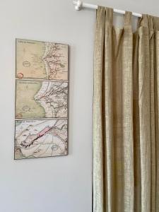 a curtain hanging on a wall next to a map at Le Petit Logis - Vue Mer in Granville