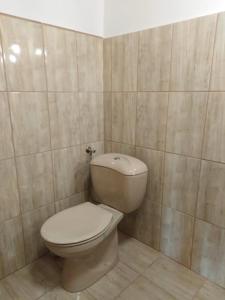 La salle de bains est pourvue de toilettes et d'un mur carrelé. dans l'établissement Recece vendégház, à Gyepükaján