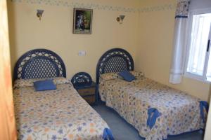 - une chambre avec 2 lits et une fenêtre dans l'établissement Apartamento en el Paseo Marítimo de Benidorm, à Benidorm