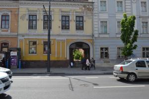 żółty budynek z ludźmi przechodzącymi przez drzwi w obiekcie Cluj Memorandumului Apt ultracentral cu parcare privata w Klużu-Napoce