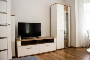 una sala de estar con TV en un armario blanco en Liepu Apartment, en Liepāja
