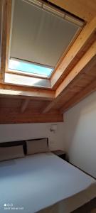 a bed in a room with a ceiling with a window at Hotel Albrici in San Bernardo