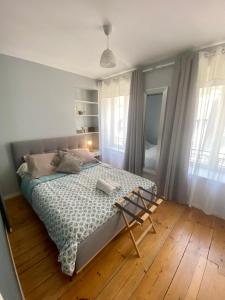 um quarto com uma cama e uma cadeira em Le Petit Logis - Vue Mer em Granville