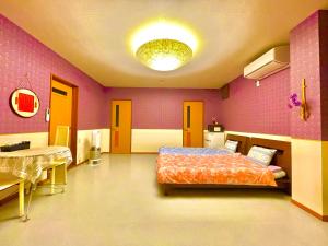 a bedroom with a bed and a table in it at 犬山モダンルーム in Inuyama