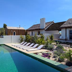 a pool with lounge chairs next to a house at Casas de Arroz in Comporta