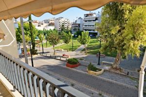 uma varanda com vista para um parque com bancos em Cozy Urban Apartment at Agios Dimitrios em Atenas
