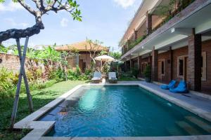 a swimming pool in the backyard of a house at Govardan Home stay in Canggu