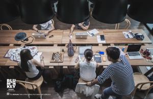 a group of people sitting at a table with laptops at Blu Monkey Hub and Hotel Phuket Town- Free All Day Coworking space in Phuket Town