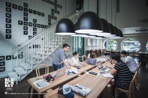 a group of people sitting at a table with laptops at Blu Monkey Hub and Hotel Phuket Town- Free All Day Coworking space in Phuket Town