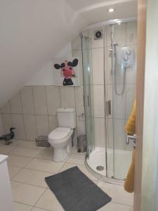 a bathroom with a toilet with a cow on the wall at Swallows Retreat: A Country Loft Apartment in Hargrave