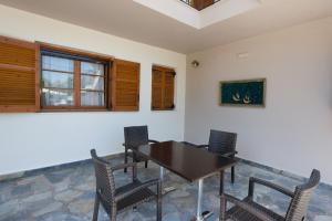 a dining room with a wooden table and chairs at Ilios Studios in Lefkada