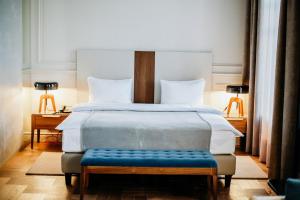 a bedroom with a large bed with a blue bench at Hotel Amurskiy in Irkutsk