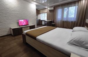 a bedroom with a bed and a tv on a table at Двухкомнатный люкс центр Соборности 29 KR Apartments in Kryvyi Rih