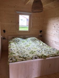 a bed in a wooden room with a window at Domek the luxe in Šluknov