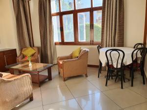 una sala de estar con una mesa y sillas en Villa 5, en Manali