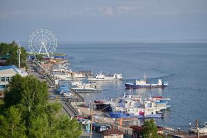a group of boats docked in a harbor with a ferris wheel at Mayak Hotel in Listvyanka