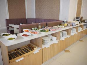 a buffet line with bowls and plates of food at Mayak Hotel in Listvyanka