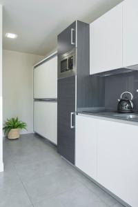 a kitchen with white cabinets and a refrigerator at FeelFree STAYS Basoa in Donostia-San Sebastián