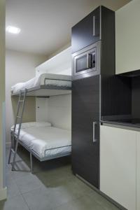 a bunk room with a bunk bed and a microwave at FeelFree STAYS Basoa in Donostia-San Sebastián