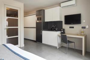 a room with a kitchen with a desk and a television at FeelFree STAYS Basoa in Donostia-San Sebastián