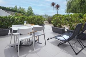 a table and chairs on a patio with plants at FeelFree STAYS Basoa in Donostia-San Sebastián