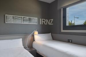two beds in a room with a window and a bedskirts at FeelFree STAYS Basoa in Donostia-San Sebastián