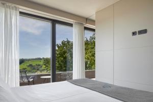a bedroom with a bed and a large window at FeelFree STAYS Basoa in Donostia-San Sebastián