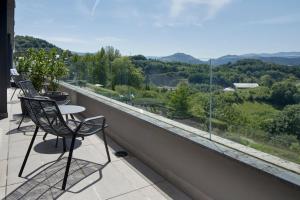 a balcony with two chairs and a table and a view at FeelFree STAYS Basoa in Donostia-San Sebastián