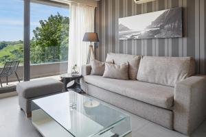 a living room with a couch and a glass table at FeelFree STAYS Basoa in Donostia-San Sebastián