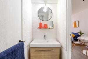 een badkamer met een wastafel en een spiegel bij Le Monocle in Châteauroux