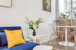 een woonkamer met een blauwe bank en een tafel bij Le Monocle in Châteauroux