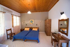 1 dormitorio con cama azul y techo de madera en Ilios Studios, en Lefkada