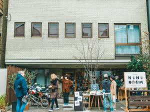 a group of people standing outside of a building at Hostel Niniroom in Kyoto
