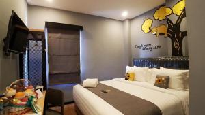 a bedroom with a bed with a tree mural on the wall at Nine Hotel in Palembang