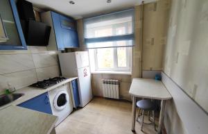 una pequeña cocina con lavadora y fregadero en Двухкомнатные апартаменты центр Mystetsʹka 3 KR Apartments, en Krivoy Rog