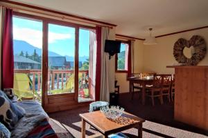 ein Wohnzimmer mit Couch und Tisch und ein Balkon in der Unterkunft Le Refuge de L'alpaga Superbe duplex au pied des pistes avec Parking couvert gratuit in La Salle Les Alpes