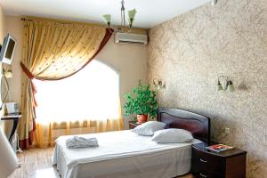 a bedroom with a bed and a large window at Boutique hotel Persona in Novokuznetsk