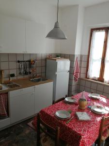 a kitchen with a table with a red table cloth at Casa di zio in Monticiano