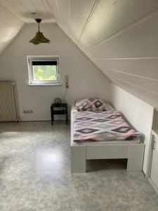 ein kleines Schlafzimmer mit einem Bett im Dachgeschoss in der Unterkunft Ferienwohnung auf Alzen in Alzen