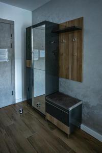 ein Badezimmer mit einer Glasdusche mit einer Bank in der Unterkunft Apartman Maja in Subotica