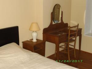 a bedroom with a dressing table and a mirror and a bed at chez gourbeix , gery papleux in Arpheuilles-Saint-Priest
