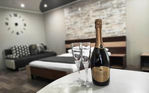 una bottiglia di champagne e due bicchieri su un tavolo di Люкс в центре Металлургов 31 KR Apartments a Kryvyj Rih