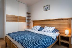 a bedroom with a bed with a blue and white comforter at TATRAMOUNT - Apartmany Bernard - Stary Smokovec in Nový Smokovec