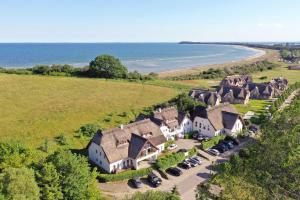 eine Luftansicht eines Hauses mit geparkten Autos in der Unterkunft strandnahe Ferienwohnung mit eigener Terrasse - Strandhaus Mönchgut FeWo 02 in Lobbe