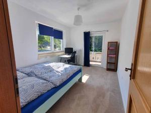 Schlafzimmer mit einem Bett, einem Schreibtisch und einem Fenster in der Unterkunft Forest Lodge in Bayerisch Eisenstein